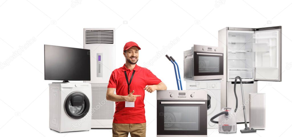 Male shop assistant in a store for electrical appliances pointing to an oven isolated on white background