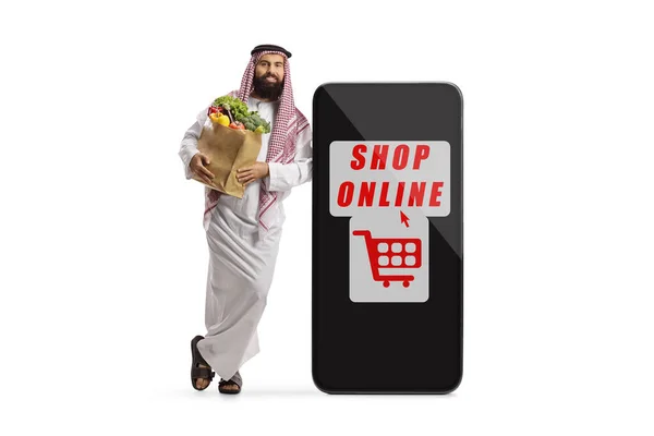 Арабський Чоловік Продуктовим Пакетом Спирається Смартфон Текстовим Магазином Онлайн Ізольованим — стокове фото