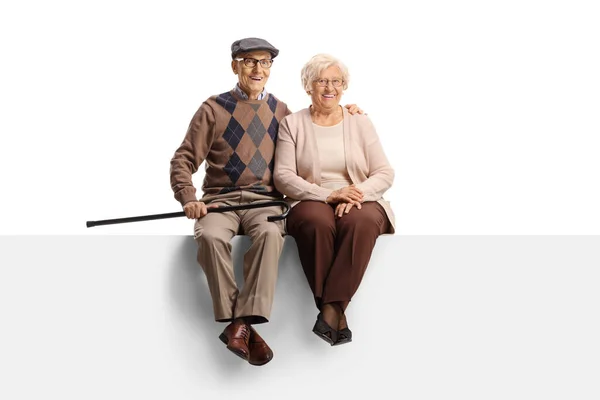 一对老年夫妇坐在一块空白的板子上 面对着被白色背景隔离的相机笑着的全长画像 — 图库照片