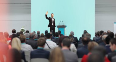 Businessman in a conference hall with many people in the audience