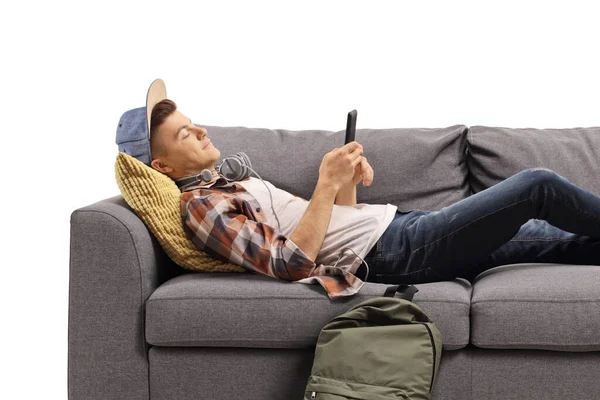 Guy Sofa Listening Music Using Smartphone Isolated White Background — стоковое фото