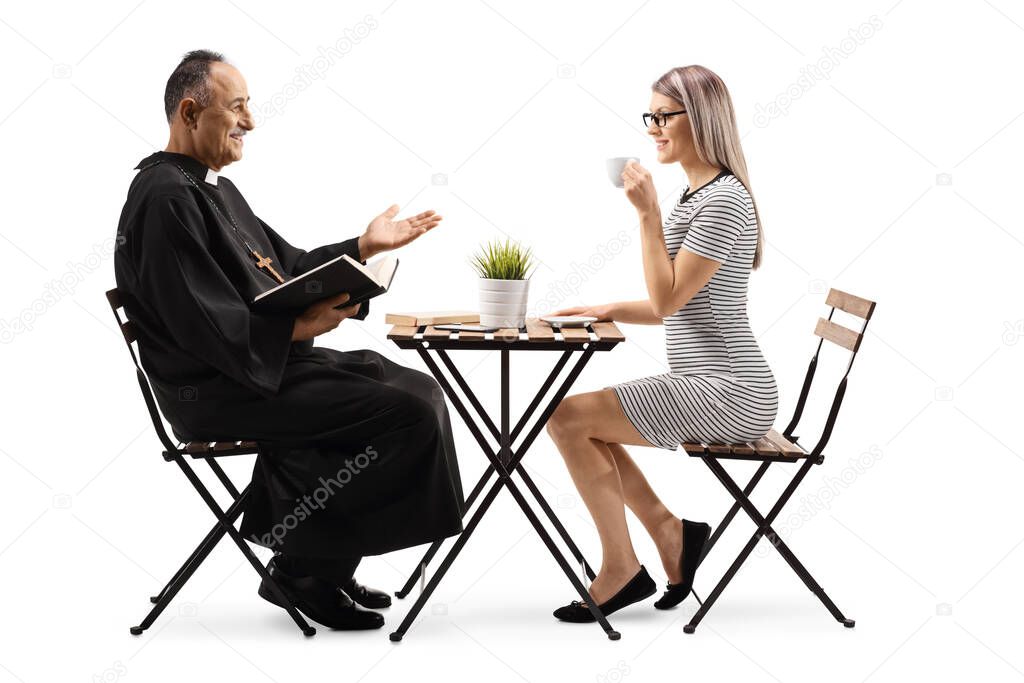 Priest in a cafe sitting and talking to a young casual woman isolated on white background