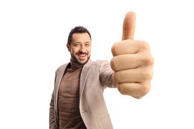 Beyaz arka planda izole edilmiş kameranın önünde baş parmak gösteren neşeli genç adam.