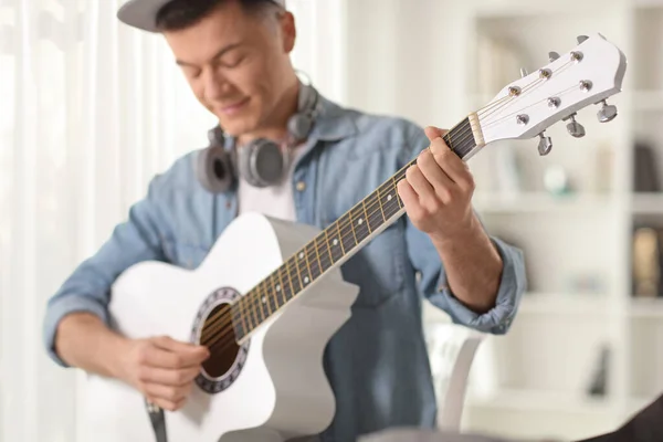 Young Man Headphones Playing Acoustic Guitar Indoors — Zdjęcie stockowe