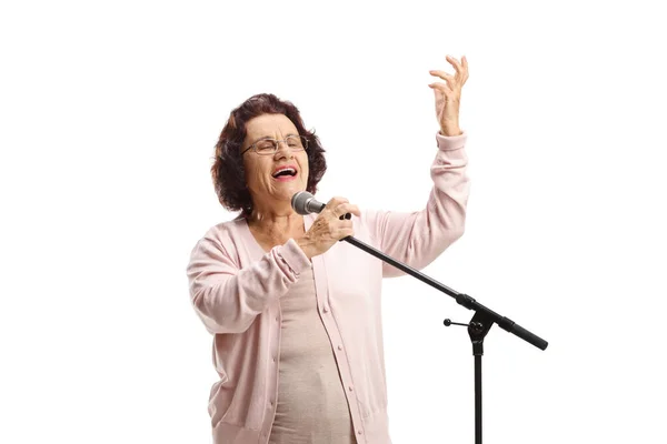 老年妇女用白色背景隔离的话筒唱歌 — 图库照片