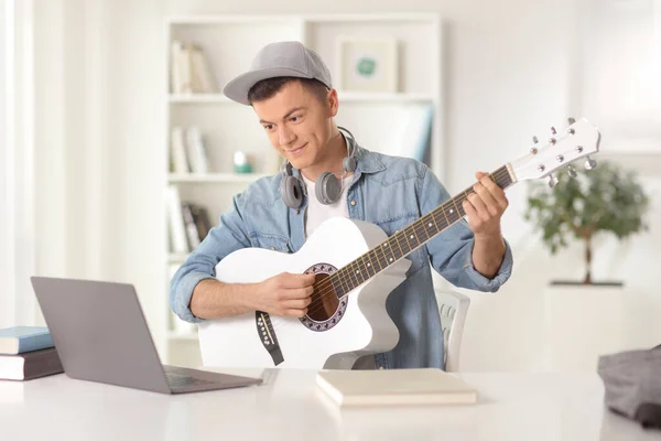 Young Man Playing Acoustic Guitar Looking Laptop Computer Home — Zdjęcie stockowe