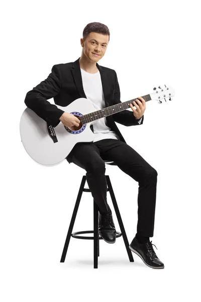 Elegancki Młody Człowiek Czarnym Garniturze Grający Gitarze Akustycznej Siedzącej Krześle — Zdjęcie stockowe