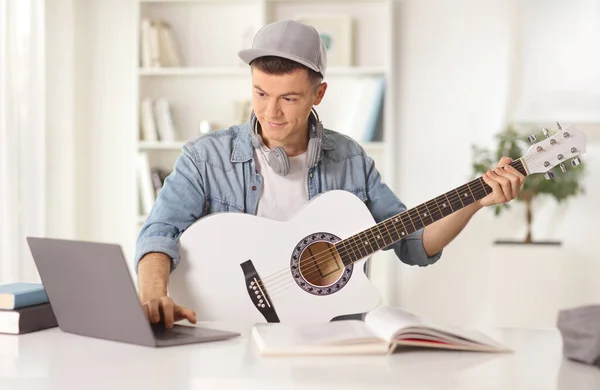 Young Man Acoustic Guitar Looking Laptop Computer Home — Zdjęcie stockowe