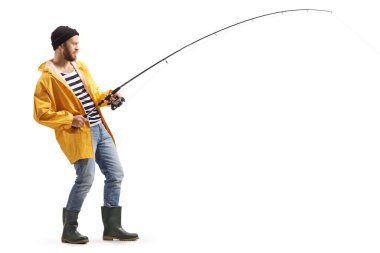 Full length profile shot of a young man in a raincoat and boots fishing with a rod isolated on white background