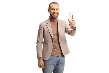 Gülümseyen genç adam beyaz arka planda izole edilmiş bir kadeh şampanya kaldırıyor.
