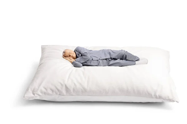 穿着睡衣的老人睡在白色背景的大枕头上 — 图库照片