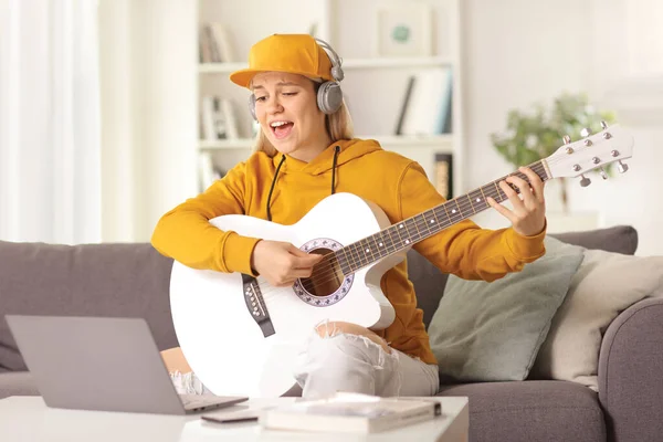 Ung Kvinna Som Spelar Akustisk Gitarr Och Sjunger Framför Bärbar — Stockfoto
