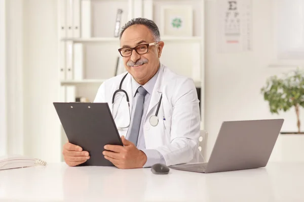 Reifer Arzt Sitzt Einem Büro Vor Einem Laptop Und Hält — Stockfoto