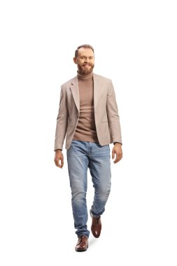 Sarışın genç adam kameraya doğru yürüyor ve beyaz arka planda izole bir şekilde gülümsüyor.