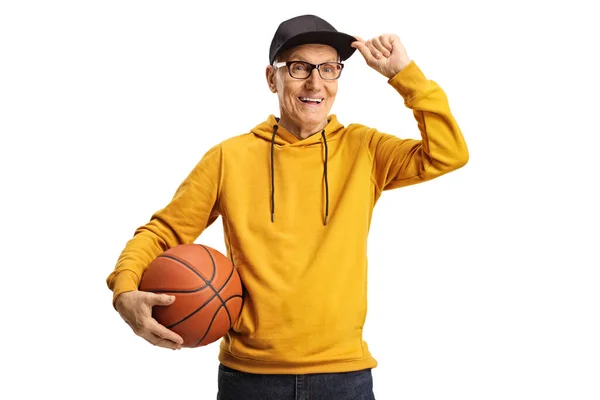 Веселый Пожилой Человек Держит Баскетбол Приветствие Шапкой Изолированы Белом Фоне — стоковое фото