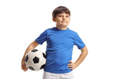 Spor formalı çocuk elinde bir futbol topu tutuyor ve beyaz arka planda yalnız poz veriyor.
