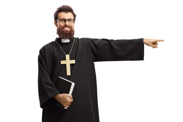 Sacerdote Segurando Uma Bíblia Apontando Para Lado Isolado Fundo Branco — Fotografia de Stock