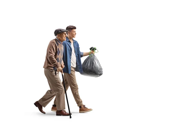 一个年轻的老人背着一个用白色背景隔离的塑料垃圾袋走着 — 图库照片