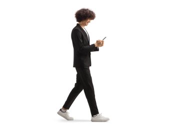 Beyaz arka planda izole edilmiş bir smrtphone kullanan ve yürüyen uzun boylu bir adamın tam boy profil çekimi.