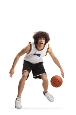 Basketbol oynayan ve beyaz arka planda izole edilmiş bir topa liderlik eden genç bir adamın tam boy portresi.