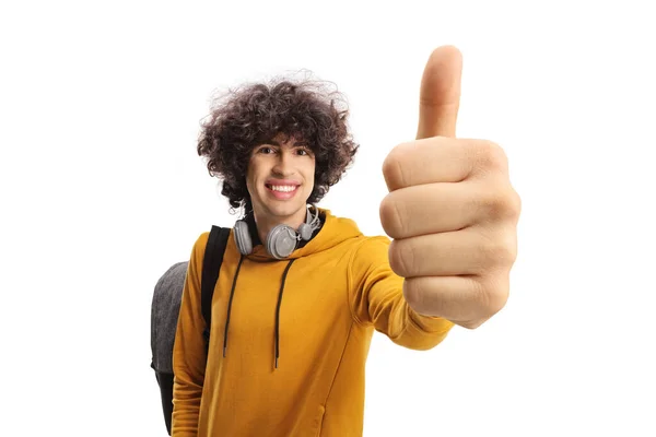快乐的男生背着背包 为一个被白色背景隔开的大拇指标志做手势 — 图库照片
