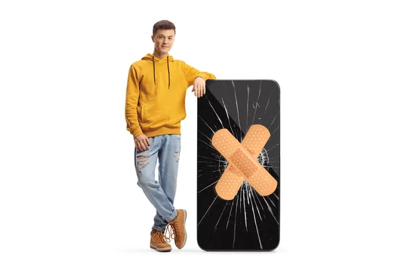 Trendy Man Leunend Een Grote Mobiele Telefoon Met Gips Het — Stockfoto
