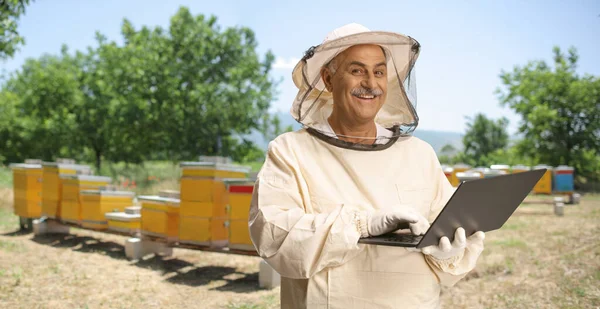 養蜂家の制服を着てノートパソコンで作業する — ストック写真