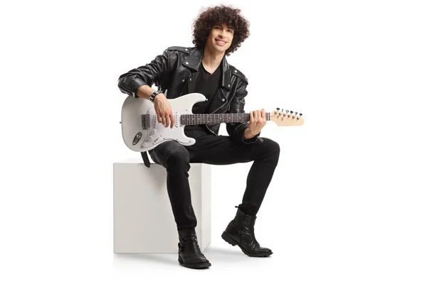 Young Male Rocker Leather Jacket Sitting White Cube Electric Guitar — Stockfoto