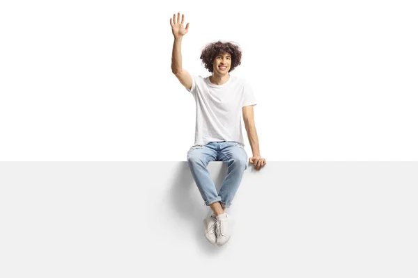 Casual Young Man Dark Curly Hair Sitting Panel Waving Isolated — Stock Photo, Image