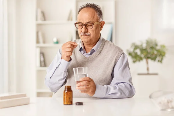 Olgun Bir Adam Ilaçlarını Alıyor Evde Bir Masada Oturuyor — Stok fotoğraf