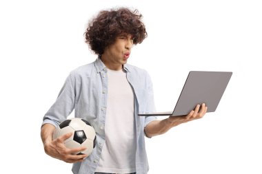 Futbol fanatiği dizüstü bilgisayar ve beyaz arka planda izole edilmiş bir top tutuyor.