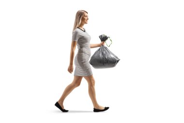 Plastik bir çöp torbası taşıyan ve beyaz arka planda tek başına yürüyen genç bir kadının tam boy profil fotoğrafı.