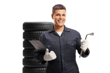 Araç lastiklerinin önünde beyaz arka planda izole edilmiş bir yığın içinde araçları tutan otomobil tamircisi