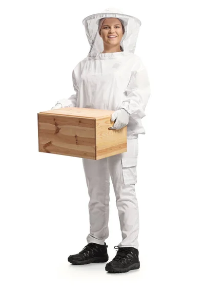 白い背景に隔離された木製の箱を持っている制服を着た若い女性の養蜂家 — ストック写真