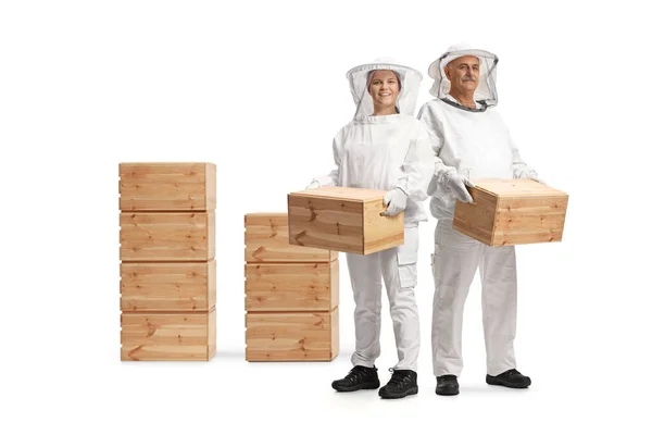 身穿制服的男女养蜂人 手持独立于白色背景的木箱 — 图库照片