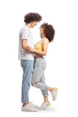 Full length profile shot of casual young couple in love hugging and looking at each other isolated on white background
