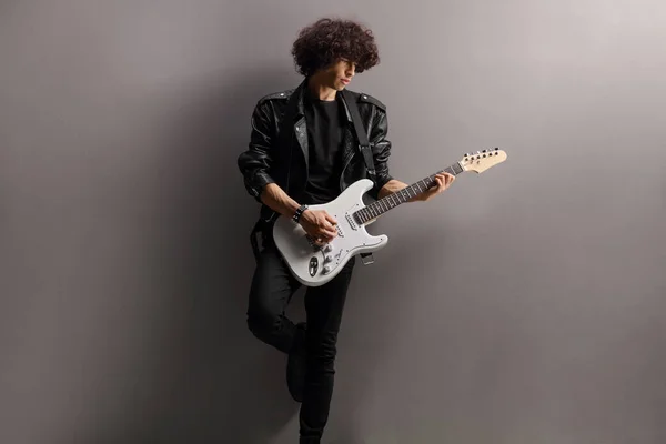 Mężczyzna Muzyk Skórzanej Kurtce Gitarą Elektryczną Opierającą Się Szarej Ścianie — Zdjęcie stockowe
