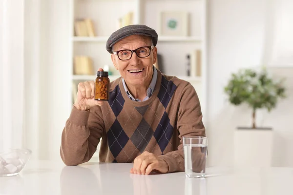 Glücklicher Älterer Mann Sitzt Hause Und Zeigt Eine Flasche Pillen — Stockfoto
