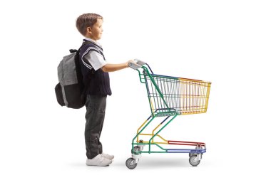 Üniformalı bir çocuğun beyaz arka planda izole edilmiş küçük boş bir alışveriş arabasıyla tam boy profil fotoğrafı.
