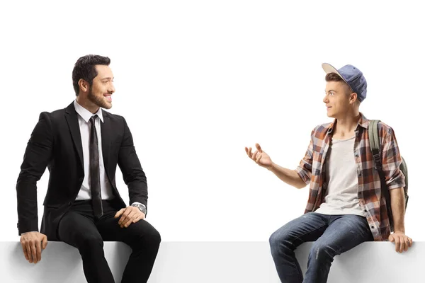 Businessman and a student sitting on a panel and talking isolated on white background