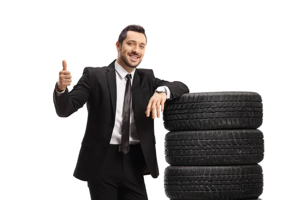 Businessman Leaning Pile Car Tires Showing Thumb Isolated White Background — Stock Photo, Image
