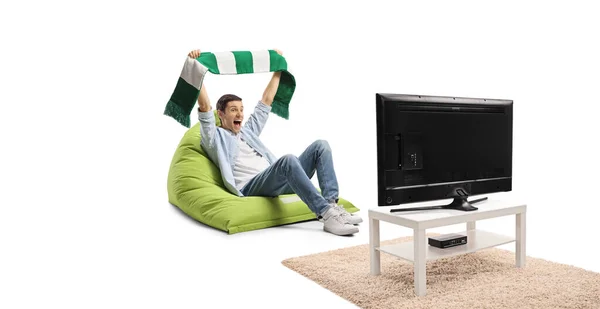 Young Man Cheering Green White Scarf Sitting Bean Bag Armchair — 图库照片