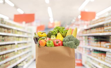 Fresh fruits and vegetables in a paper bag in a supermarket