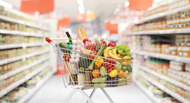 Full shopping cart with groceries inside a supermarket