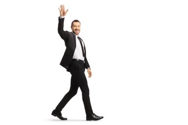 Full length shot of a young businessman walking and waving isolated on white background