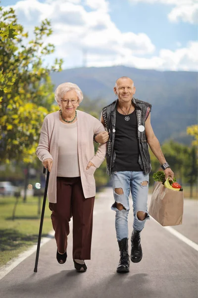Man Helping Senior Woman Walking Cane Carrying Grocery Bag Outdoors — Fotografia de Stock
