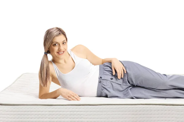 Woman Lying Bed Mattress Pajamas Smiling Camera Isolated White Background — Stockfoto