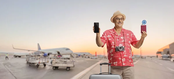 Mature Male Tourist Suitcase Showing Passport Smartphone Airport Apron —  Fotos de Stock