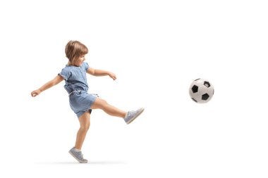 Full length shot of a little girl kicking a football isolated on white background