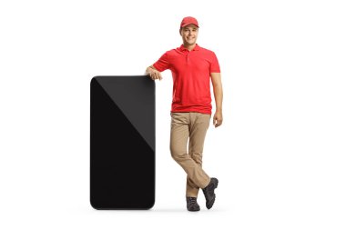 Beyaz arkaplanda izole edilmiş büyük bir cep telefonunun yanında duran bir tezgahtarın tam boy portresi